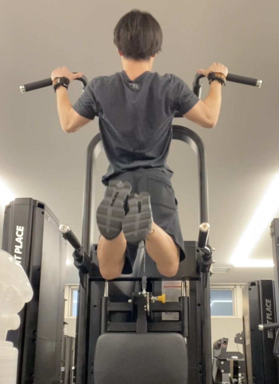 懸垂バーにぶら下がってチンニング（懸垂）をしている様子