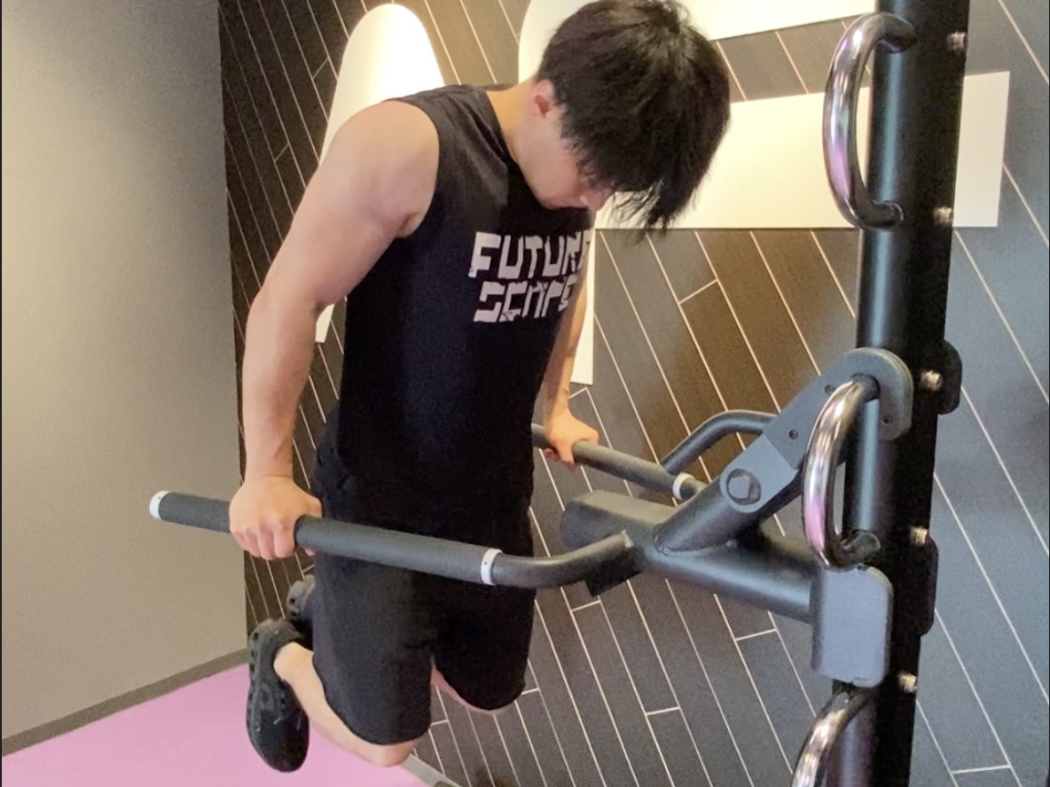 ディップスのバーにぶら下がってディップスをしている様子