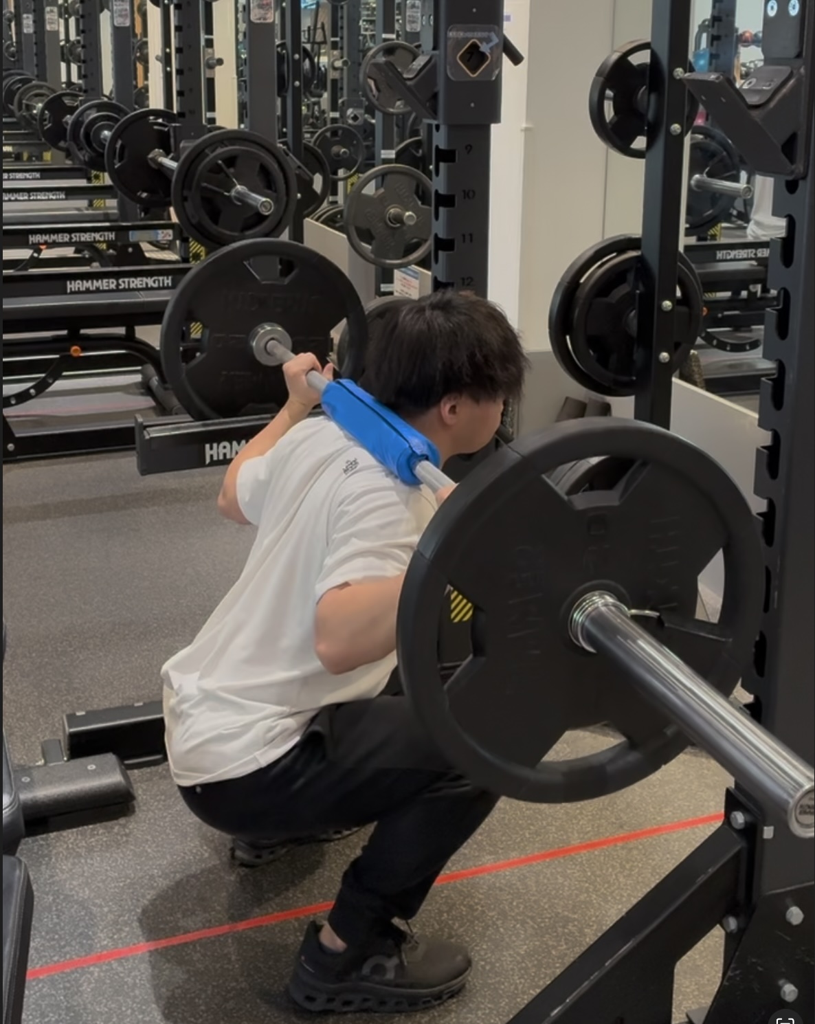 バーベルを担ぎ、スクワットをしている様子