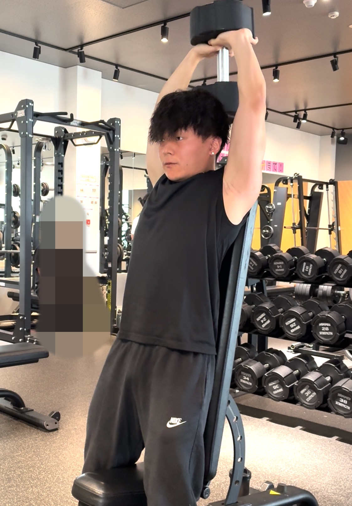 ダンベルを持ち上げ、フレンチプレスをしている様子